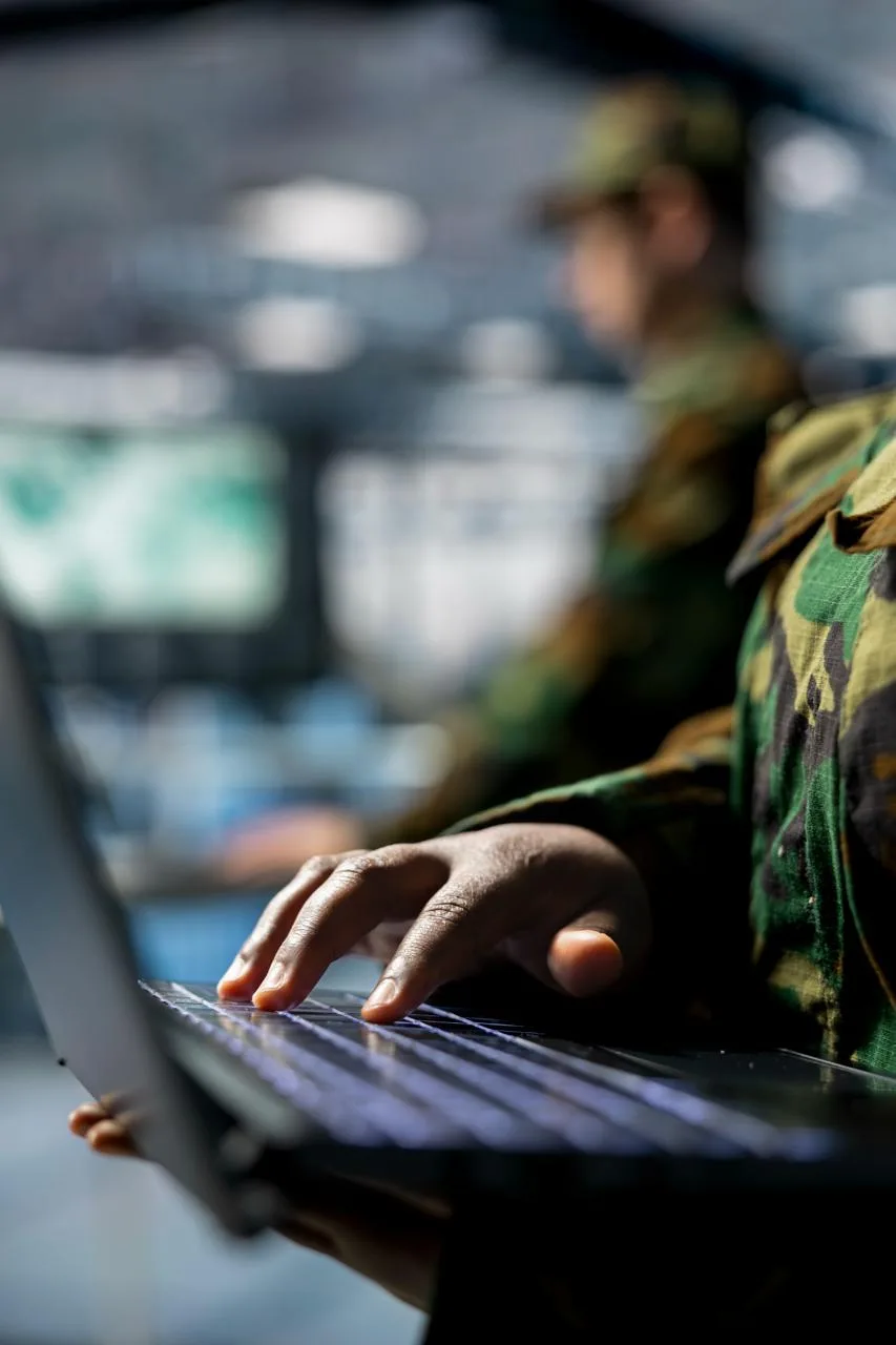 Uniformed personnel working on laptops in a government operations center — the public-sector teams Globeo books lodging for